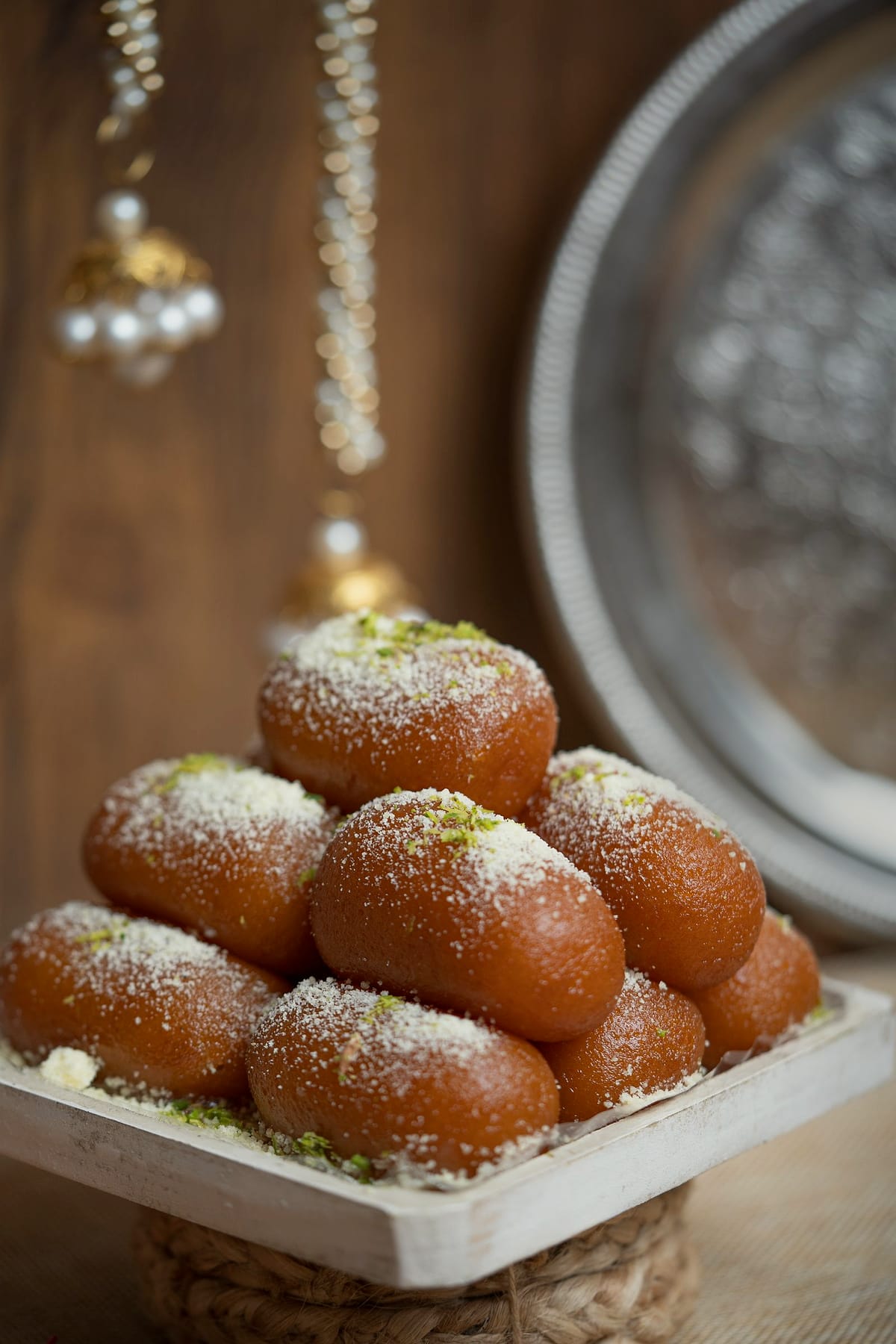 Golden-brown pantua rolled in grated coconut on a white tray.